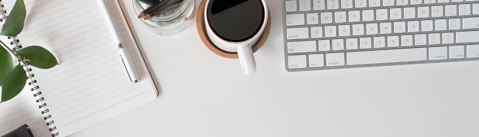 Schreibtisch auf dem Mann Kaffe und eine Tastatur sowie...